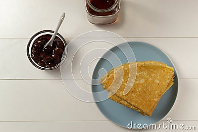 Pancakes Russian Blini with strawberry jam and tea on a white background. Breakfast. Ð¡lose up. Ð¢op view Stock Photo